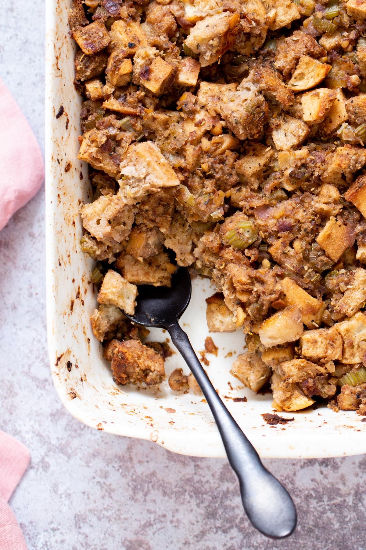 vegan stuffing  vegan stuffing in a white casserole dish with a spoon