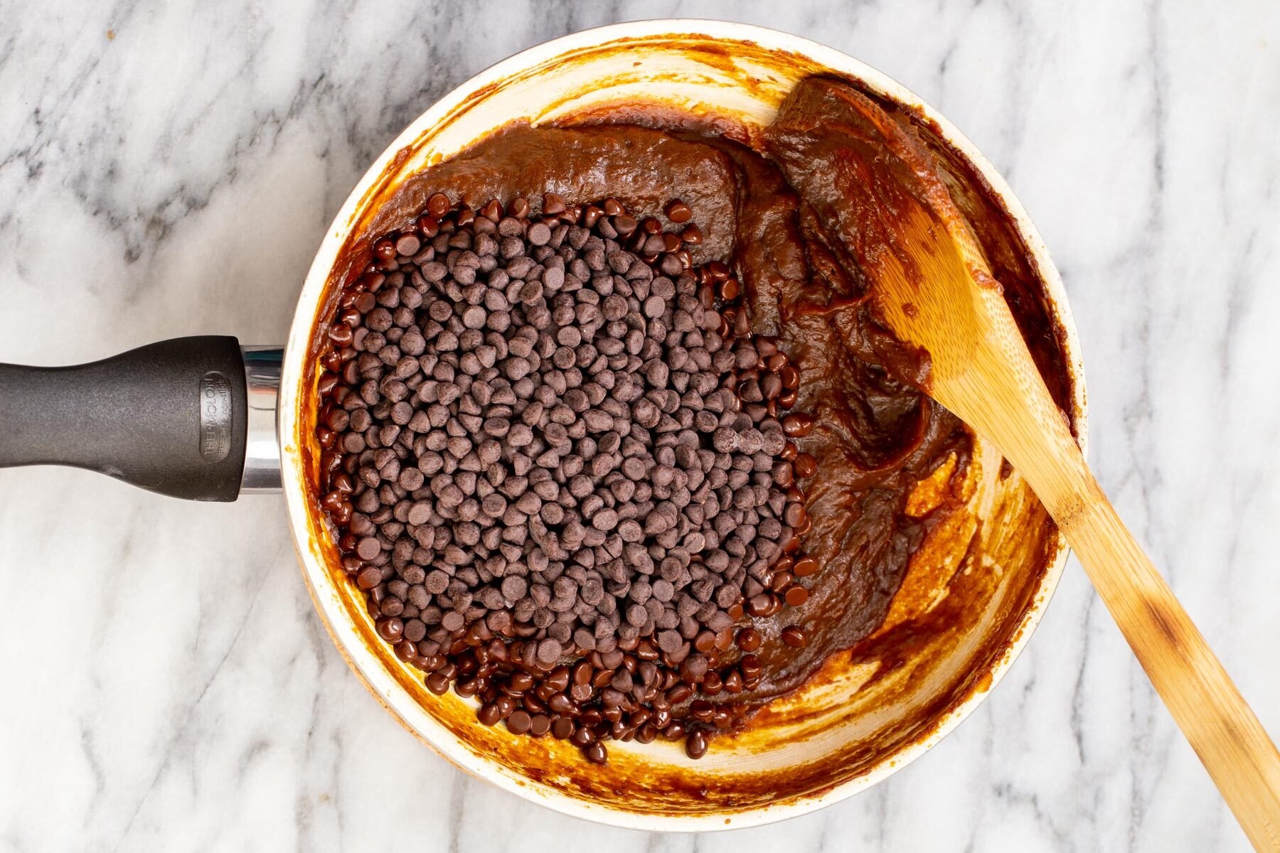 chocolate chips and pumpkin puree in a small pot on a marble surface