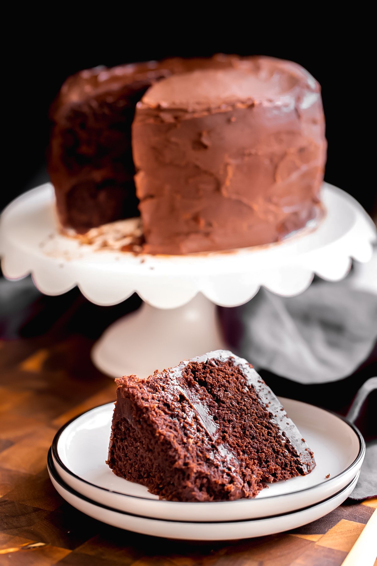a slice of vegan glutenfree chocolate layer cake on a white platter