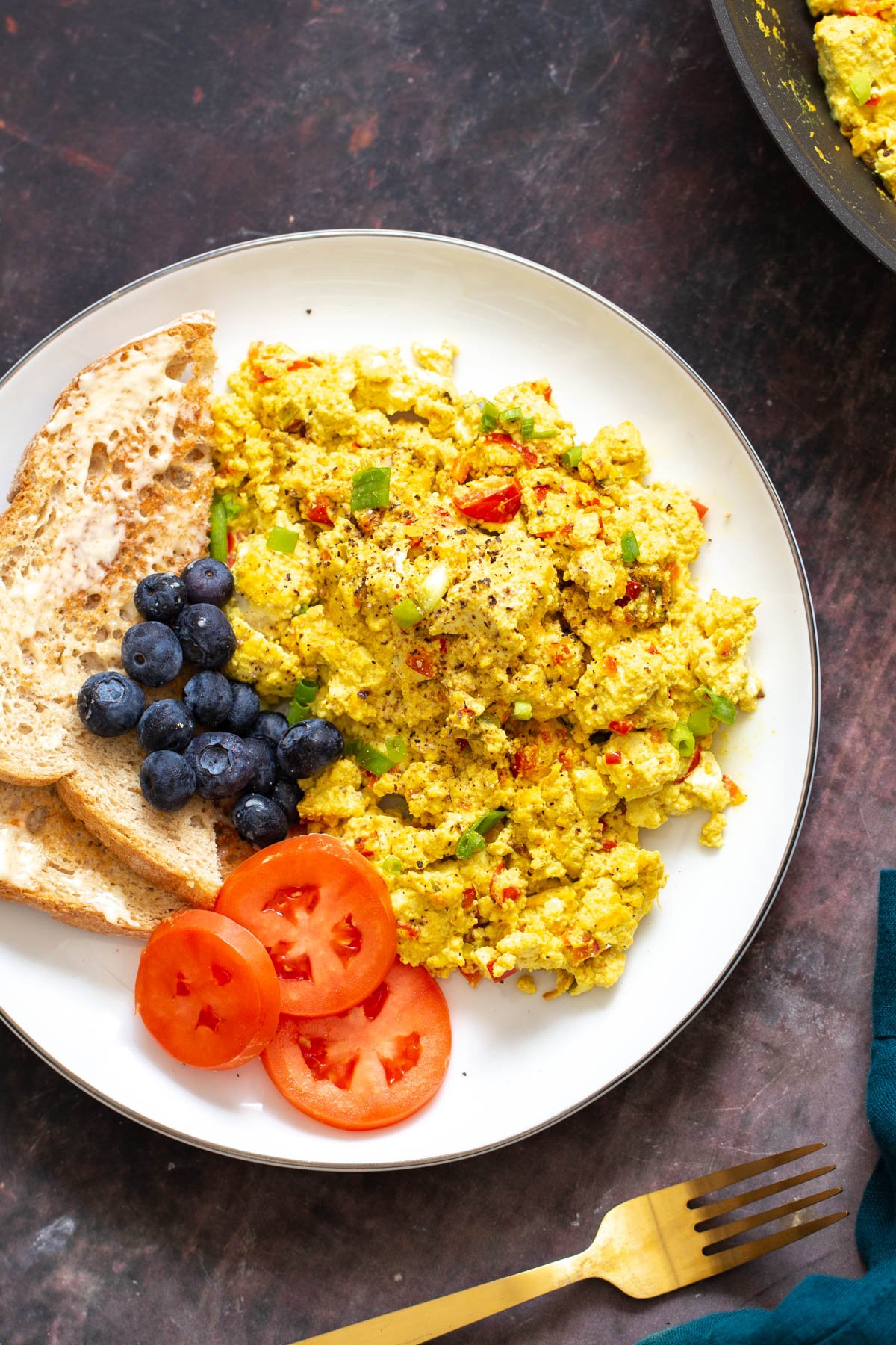 vegan tofu scramble vegan scrambled eggs made with tofu scramble seasoning served with blueberries, toast and tomatoes