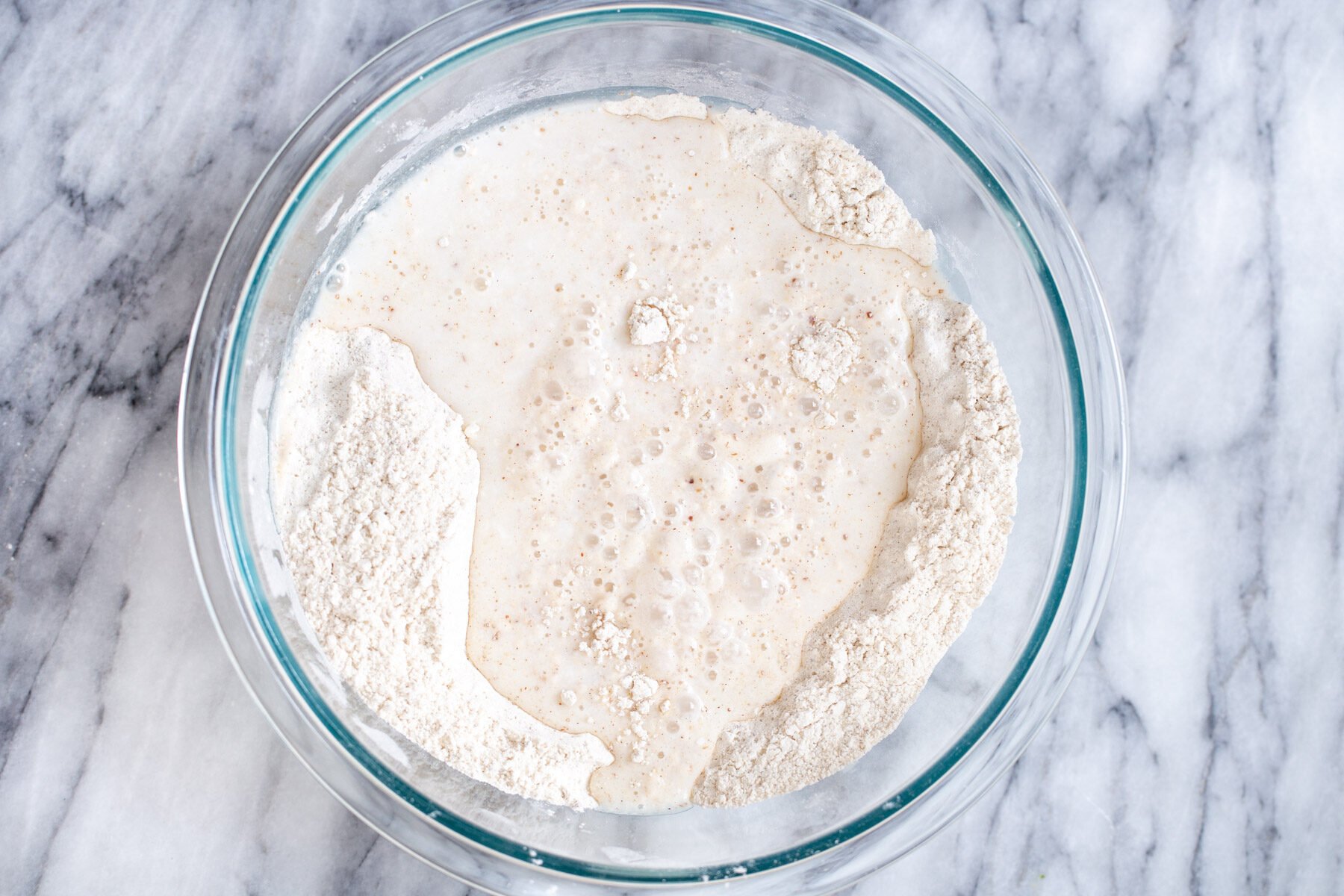 wet and dry ingredients for vegan sheet pan pancakes in a glass bowl 