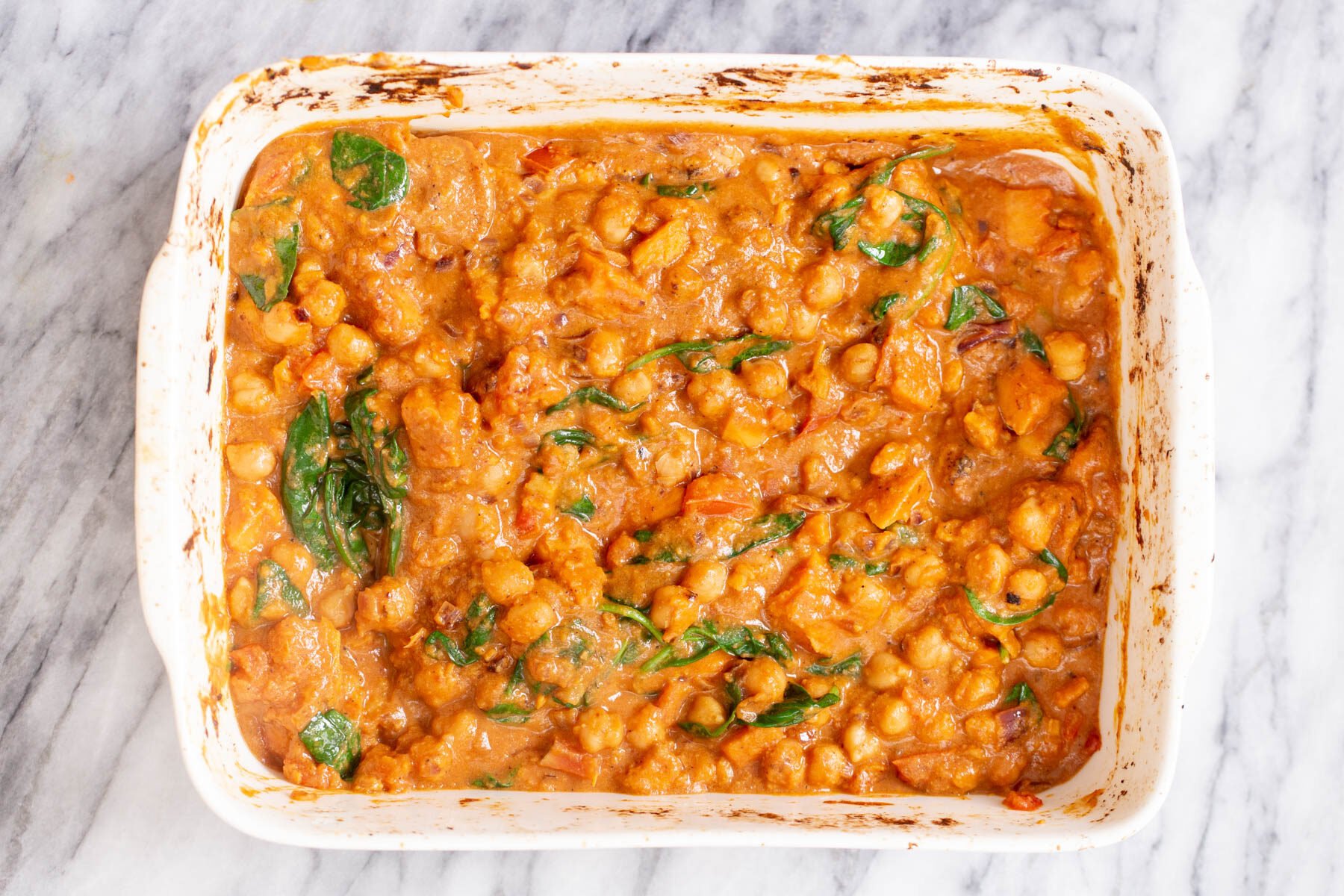 chickpea sweet potato curry spinach being added to sweet potato chickpea curry