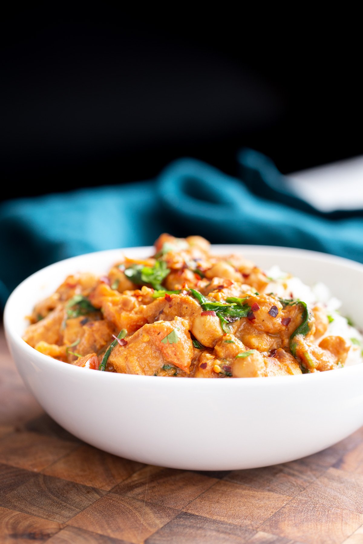 sweet potato chickpea curry side view of a bowl of vegan chickpea sweet potato curry served over rice
