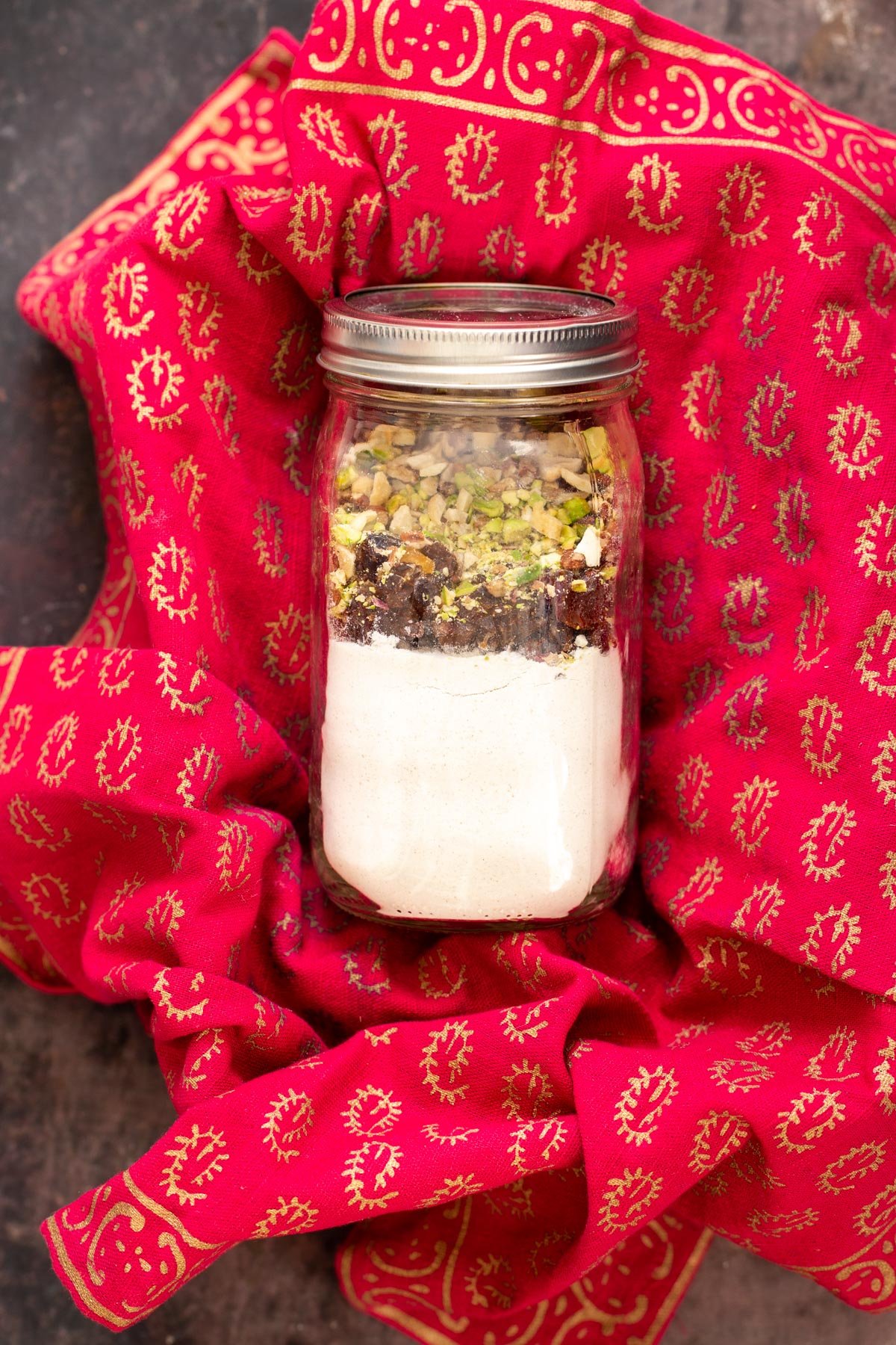 date nut cookie mix in a jar on red Christmas wrapping paper