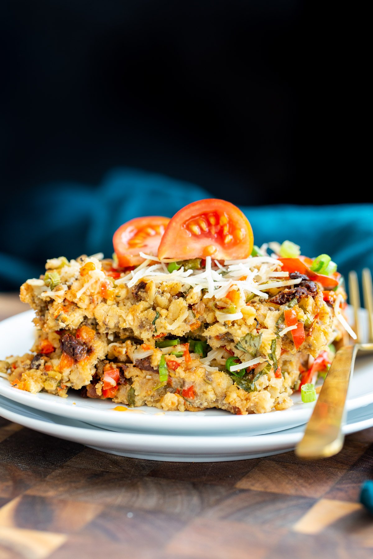 a piece of savory pizza baked oatmeal topped with tomatoes and shredded mozarella cheese