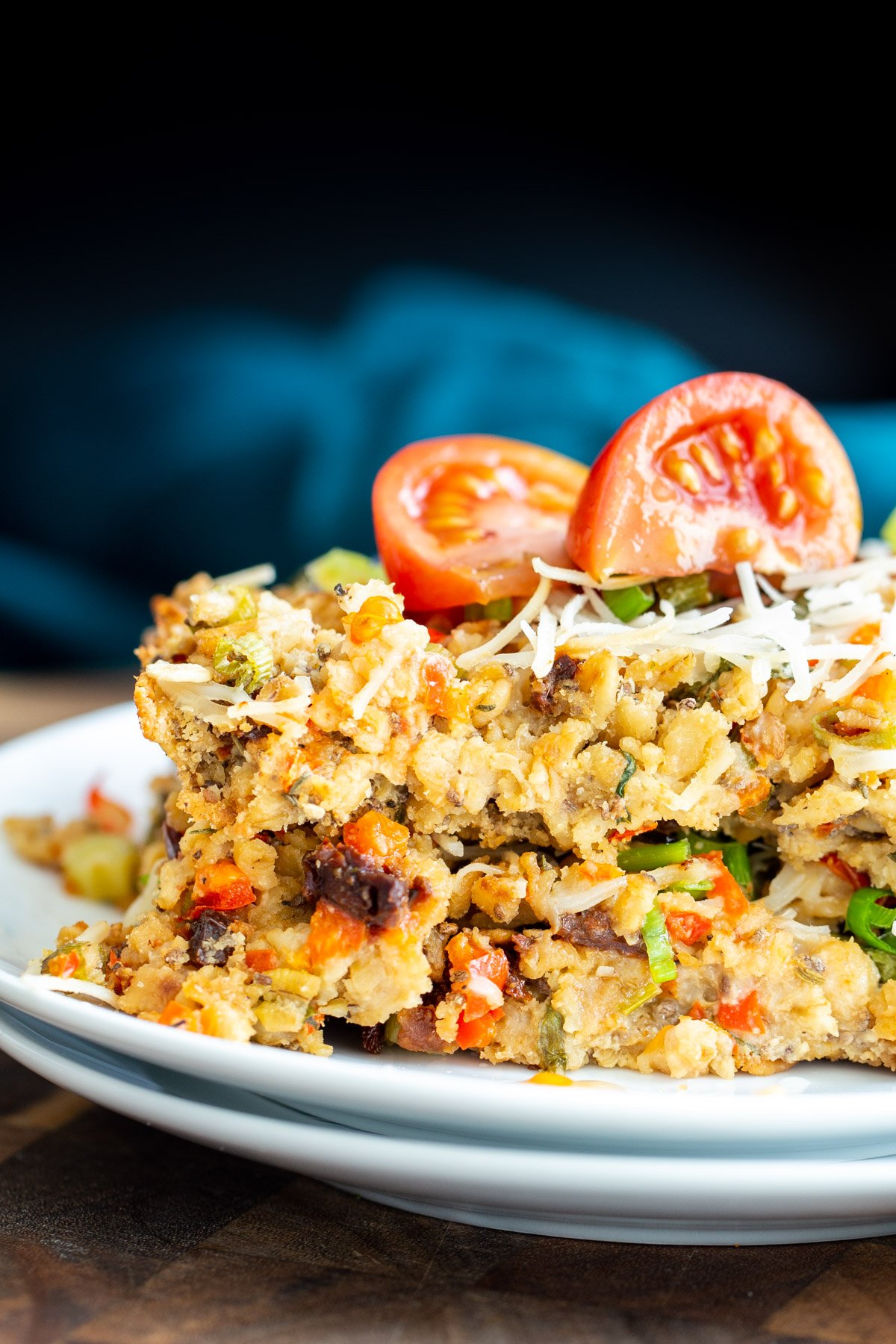 savory oatmeal bake  a slice of savory pizza oatmeal bake topped with vegan mozzarella and tomatoes