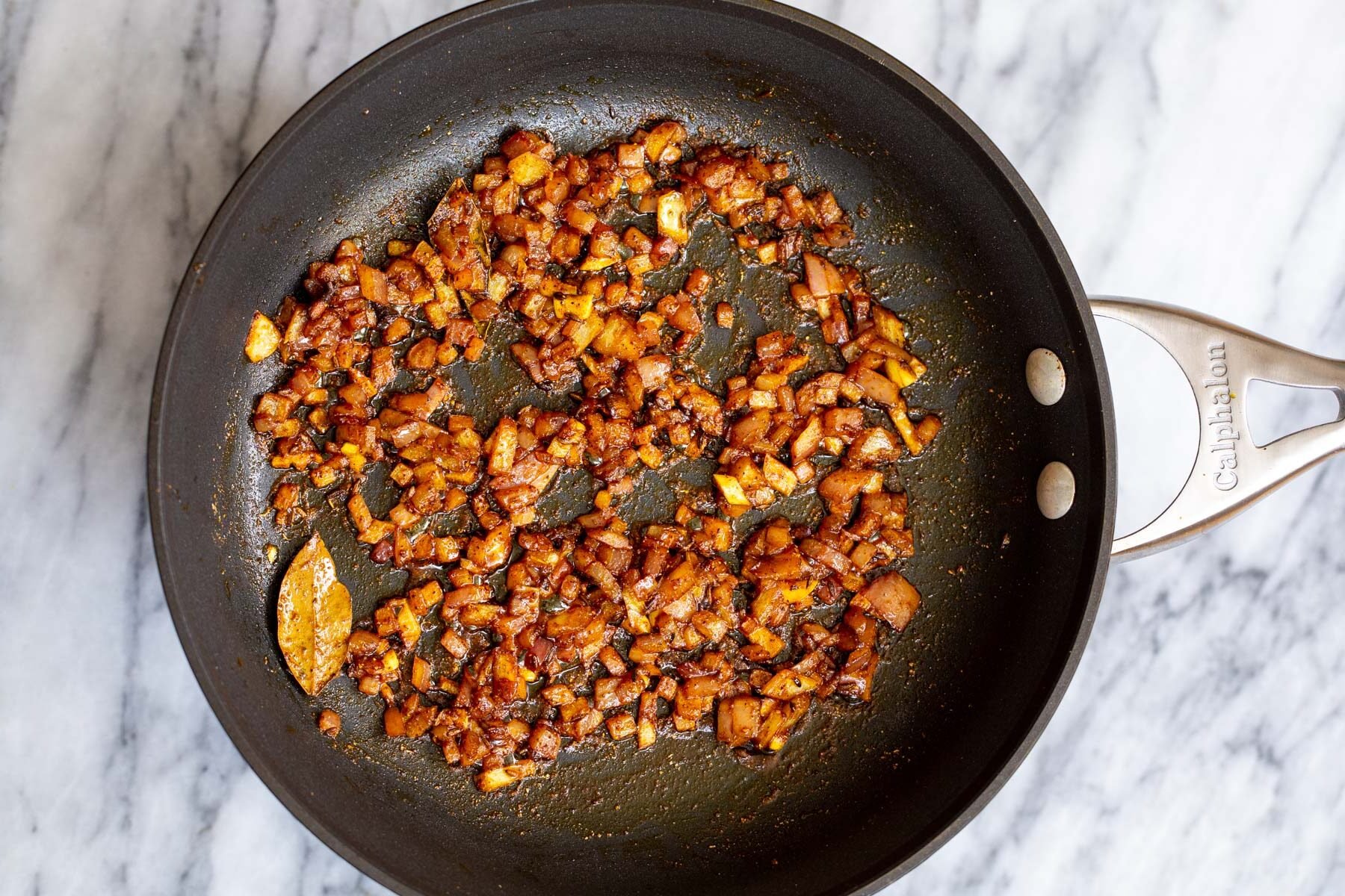 fried onions with Indian spices in a black skillet