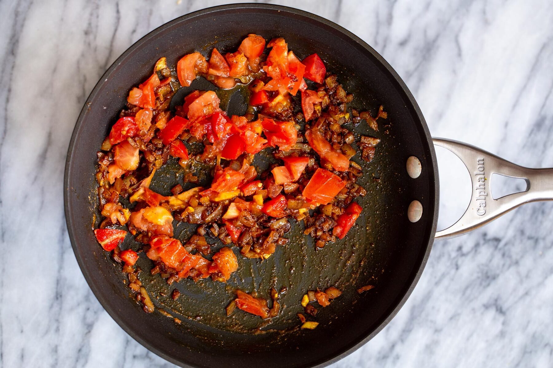 fresh tomates, onions and spices in a black skillet
