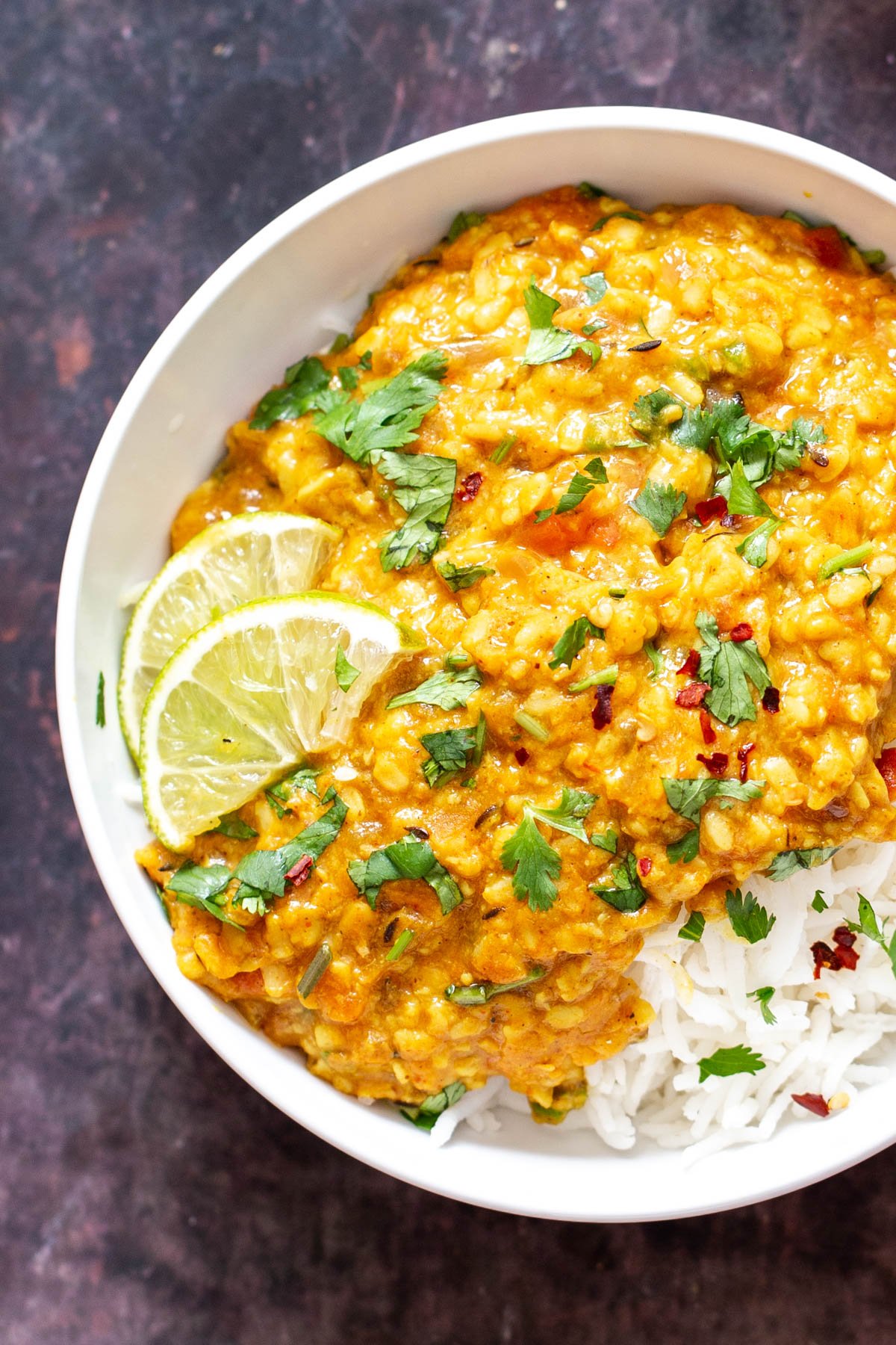 spicy urad dal spicy urad dal served over rice with some lime slices and sprinkled with cilantro