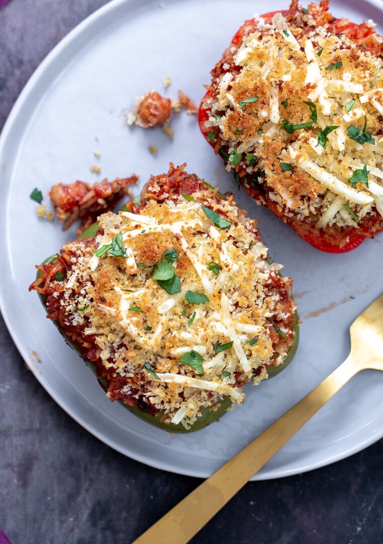 vegan stuffed bell peppers two stuffed bell peppers filled with rice and topped with cheese and bread crumbs