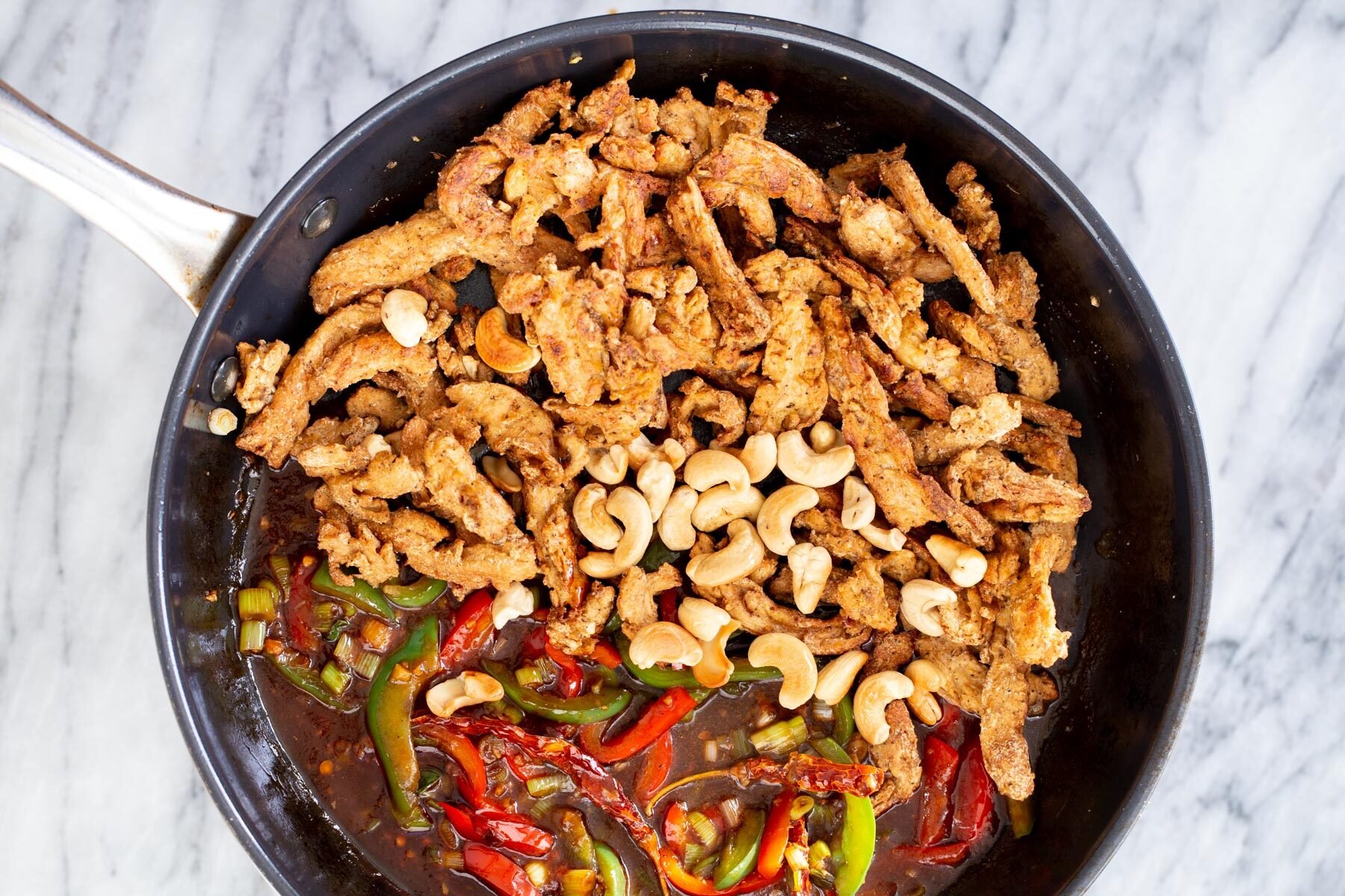 soycurls and cashew nuts being added to stir-fried veggies