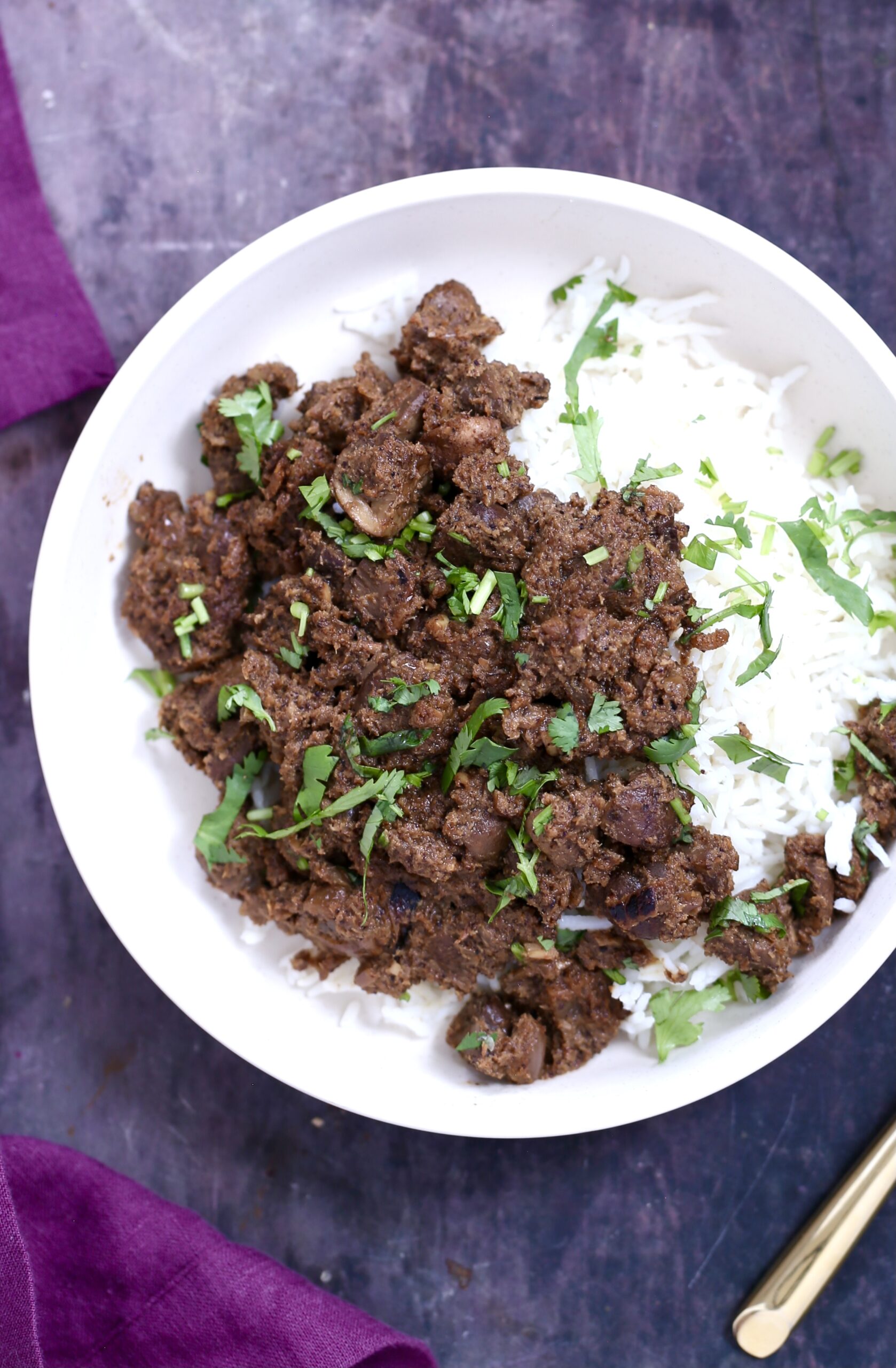 a serving of vegan mushroom xacuti with rice in a white bowl
