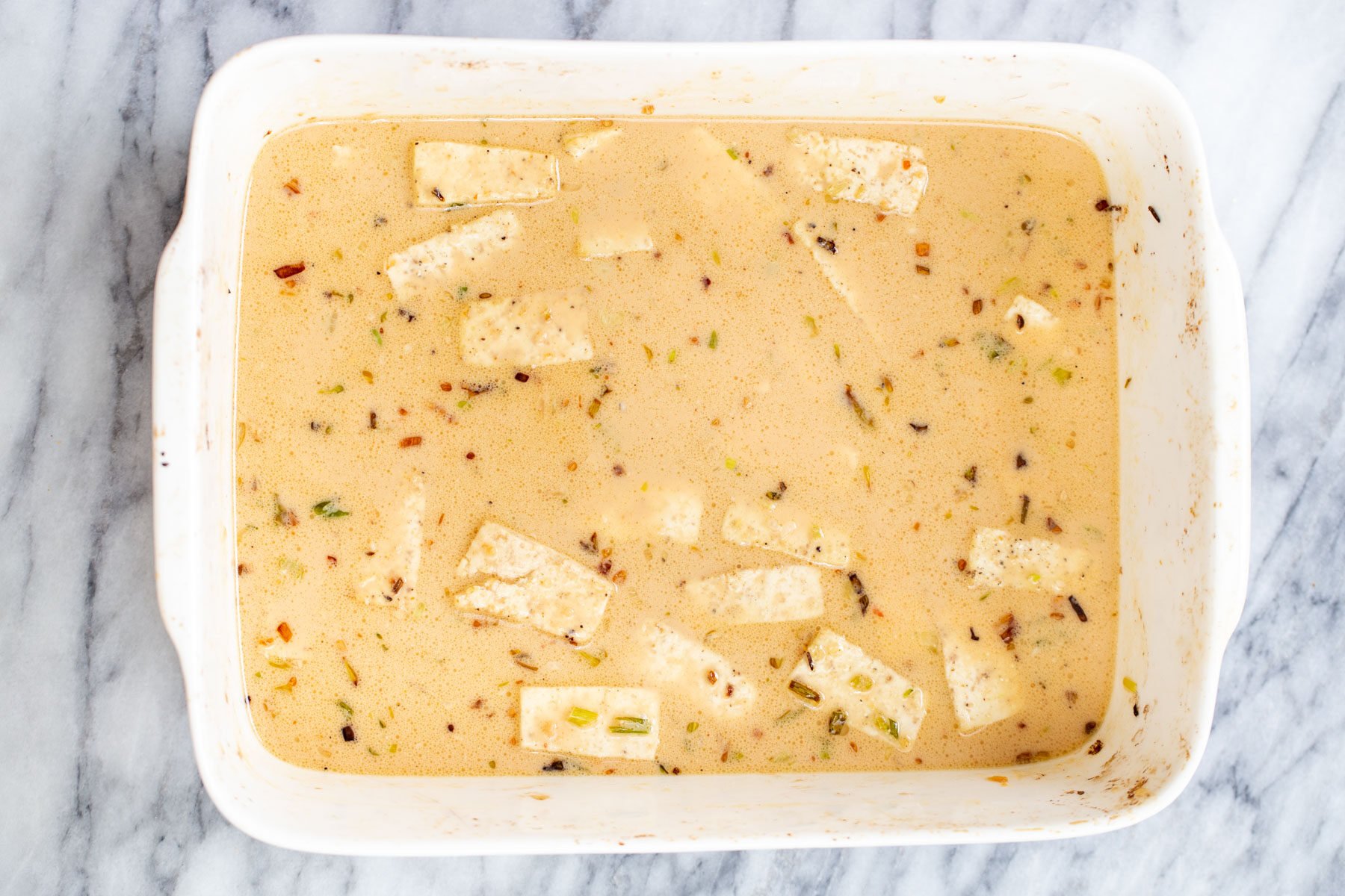 tofu cubes in peanut butter sauce in a casserole dish