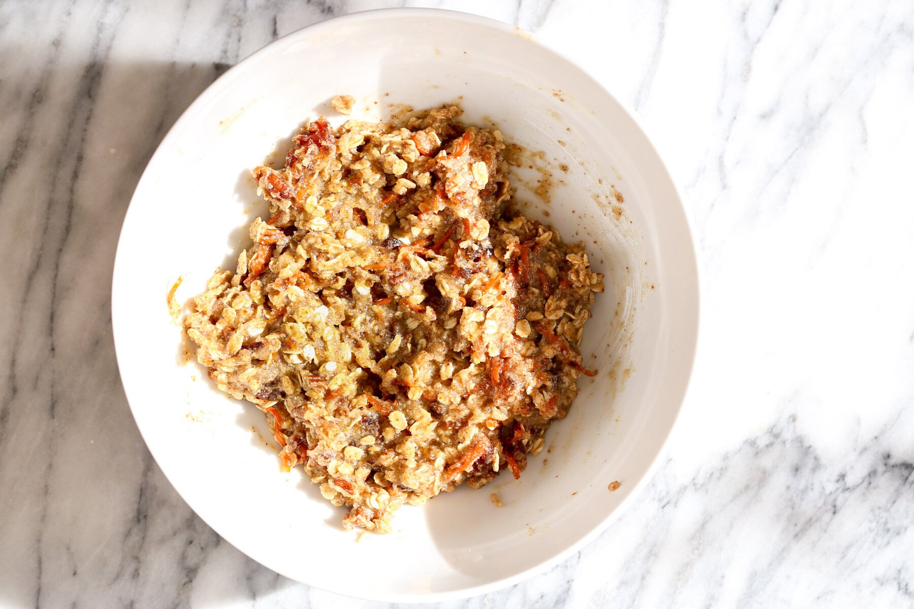 carrots oatmeal cookie dough in a white bowl