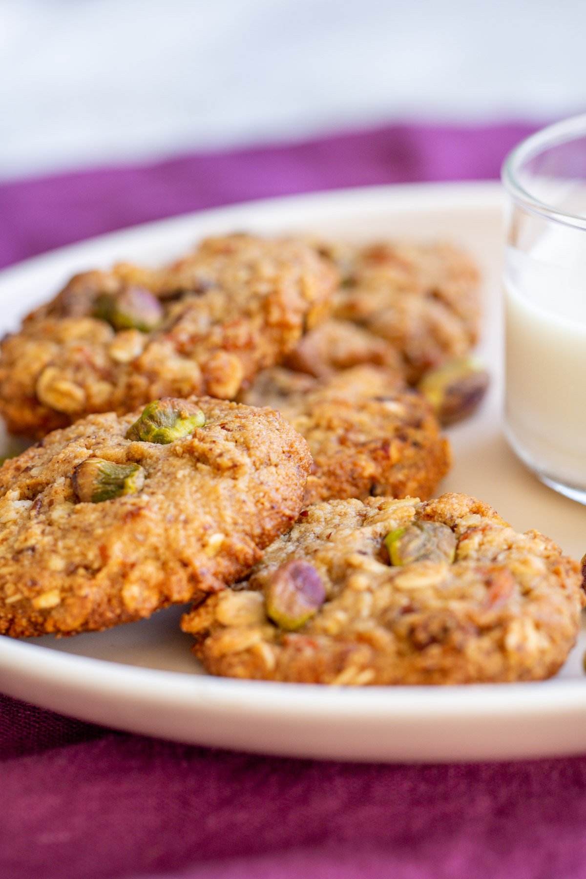 vegan carrot cake oatmeal cookies arranged around a glass of milk