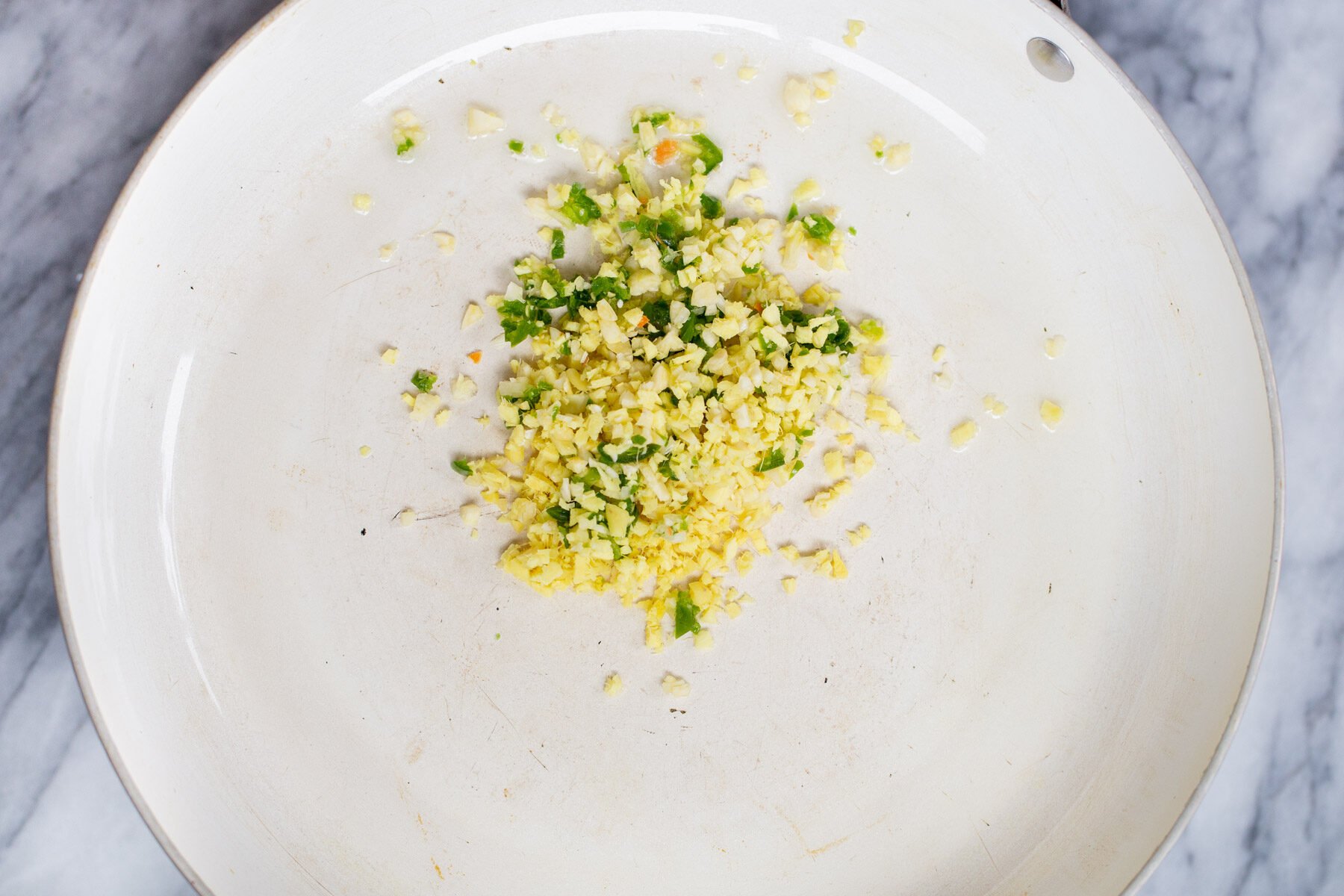 minced ginger and garlic in a sauteeing pan