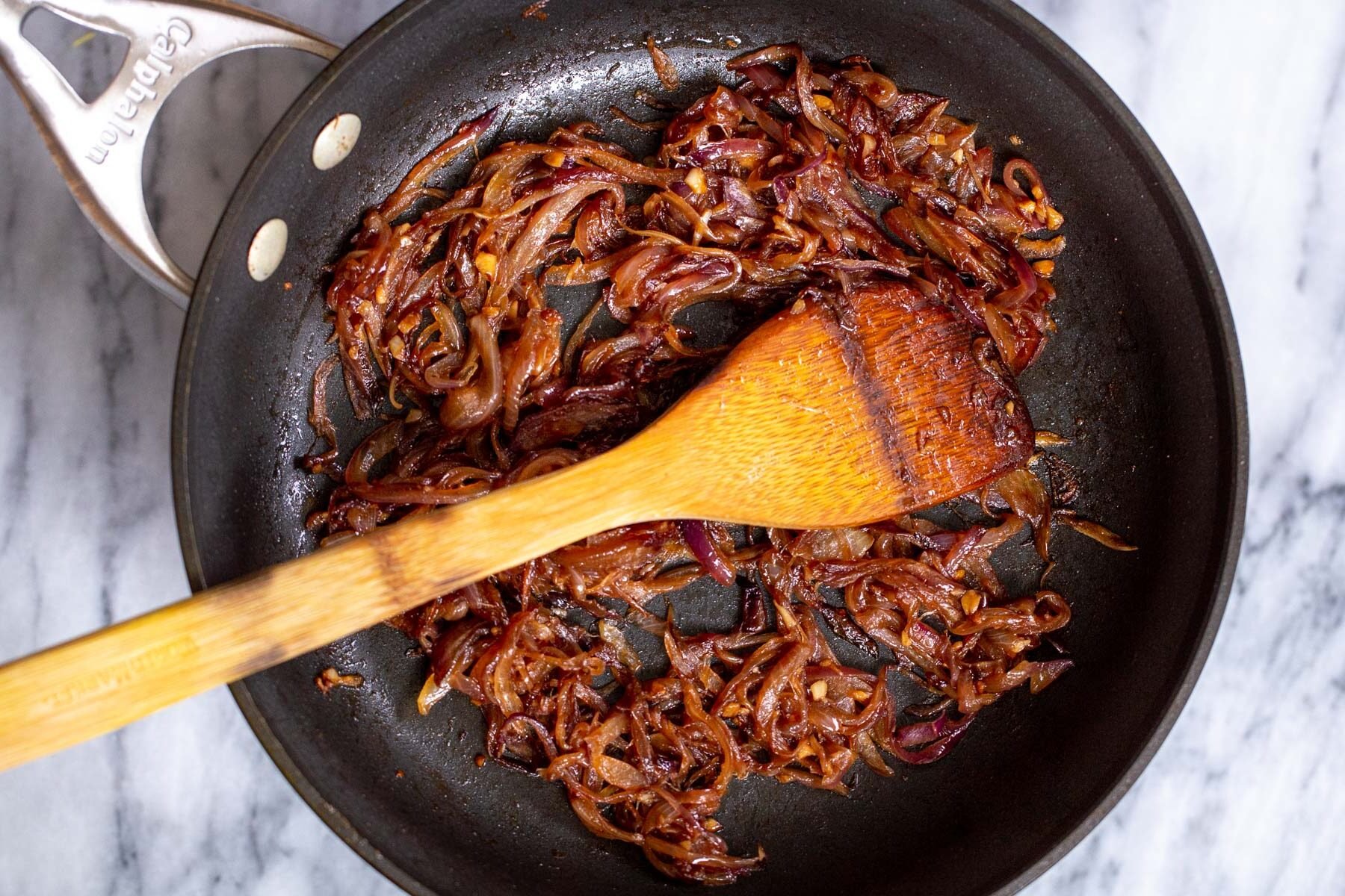 red onions, garlic and ginger in a black sauteeing pan