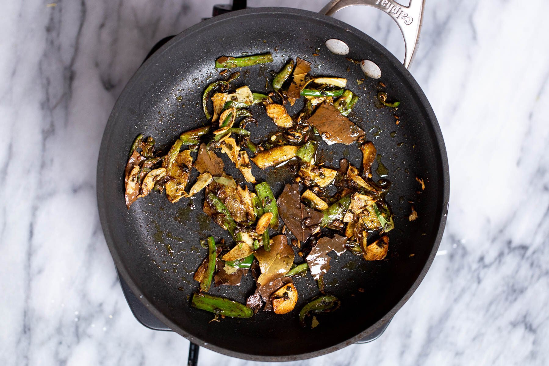 masoor tadka daal tempered green chile and ginger in a black sauteeing pan