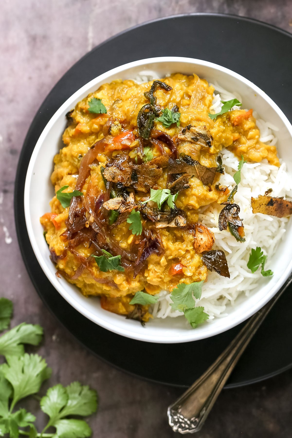 red lentil daal served over rice sprinkled with cilantro