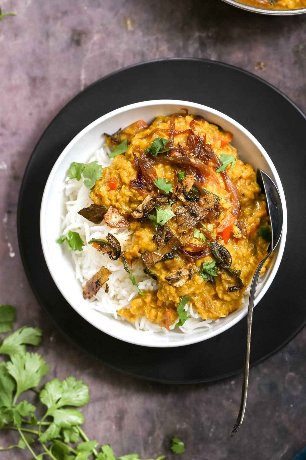masoor dal tadka served over rice sprinkled with cilantro