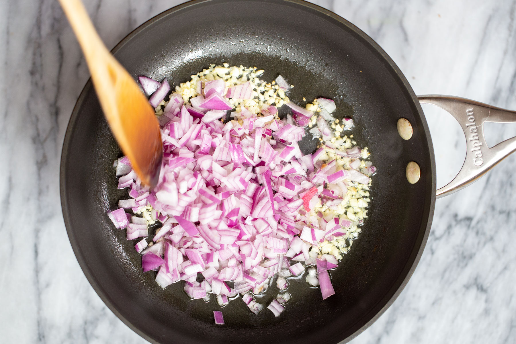 minced garlic and chopped red onions in a pan