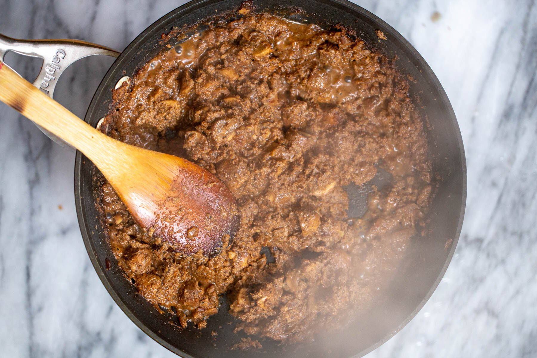 vegan Goan mushroom curry with coconut being cooked in a skillet