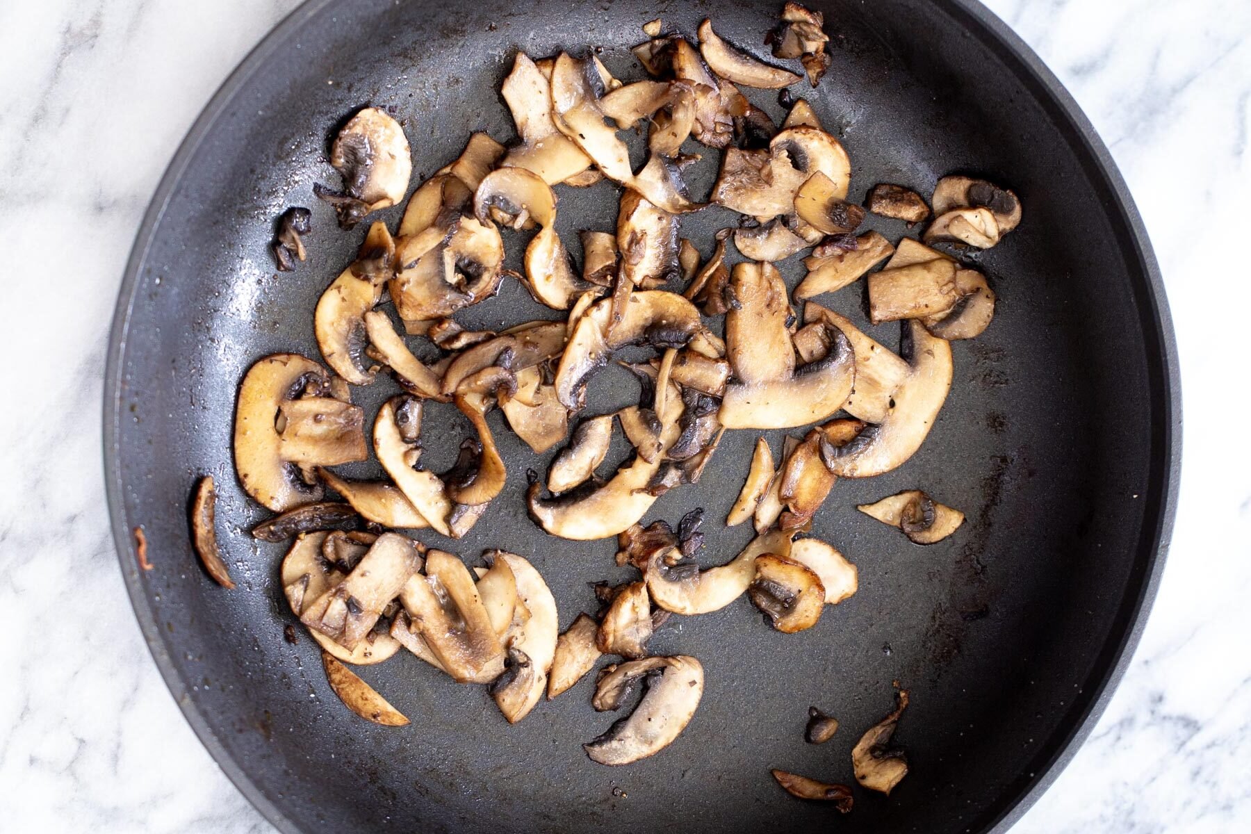 mushrooms being sauteed in a frying pan
