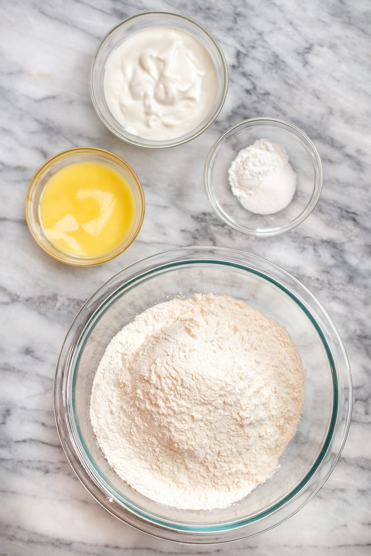 ingredients for naan bread dough on a marble counter