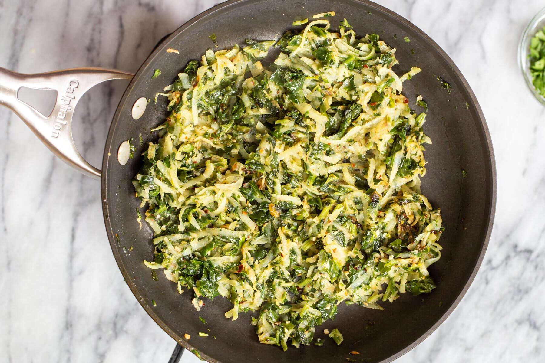 grated potato and spinach naan bread filling in a skillet