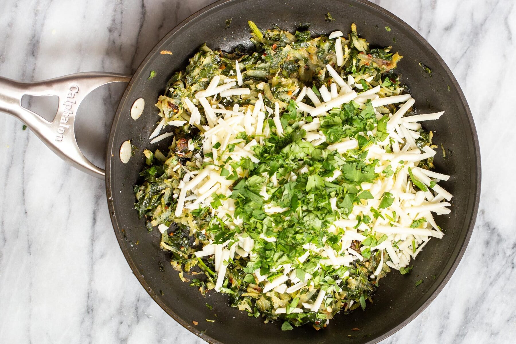 vegan spinach and cheese naan bread filling in a black skillet
