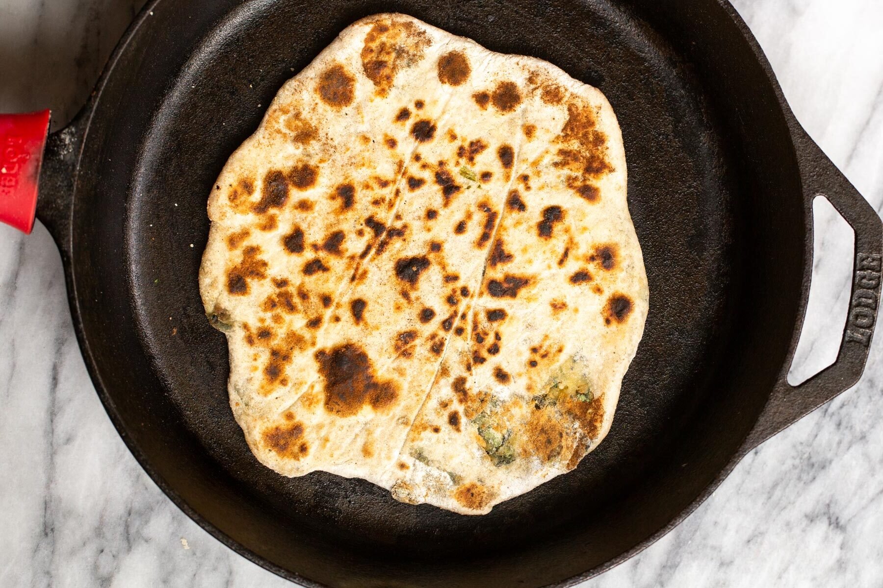 vegan stuffed naan baking in a skillet