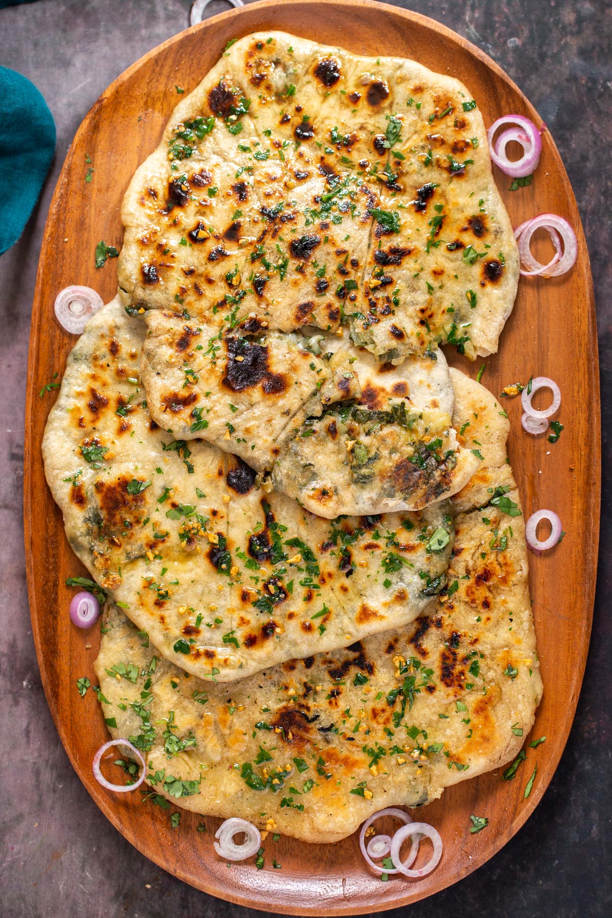 a platter with stuffed vegan garlic naan brushed with melted vegan butter