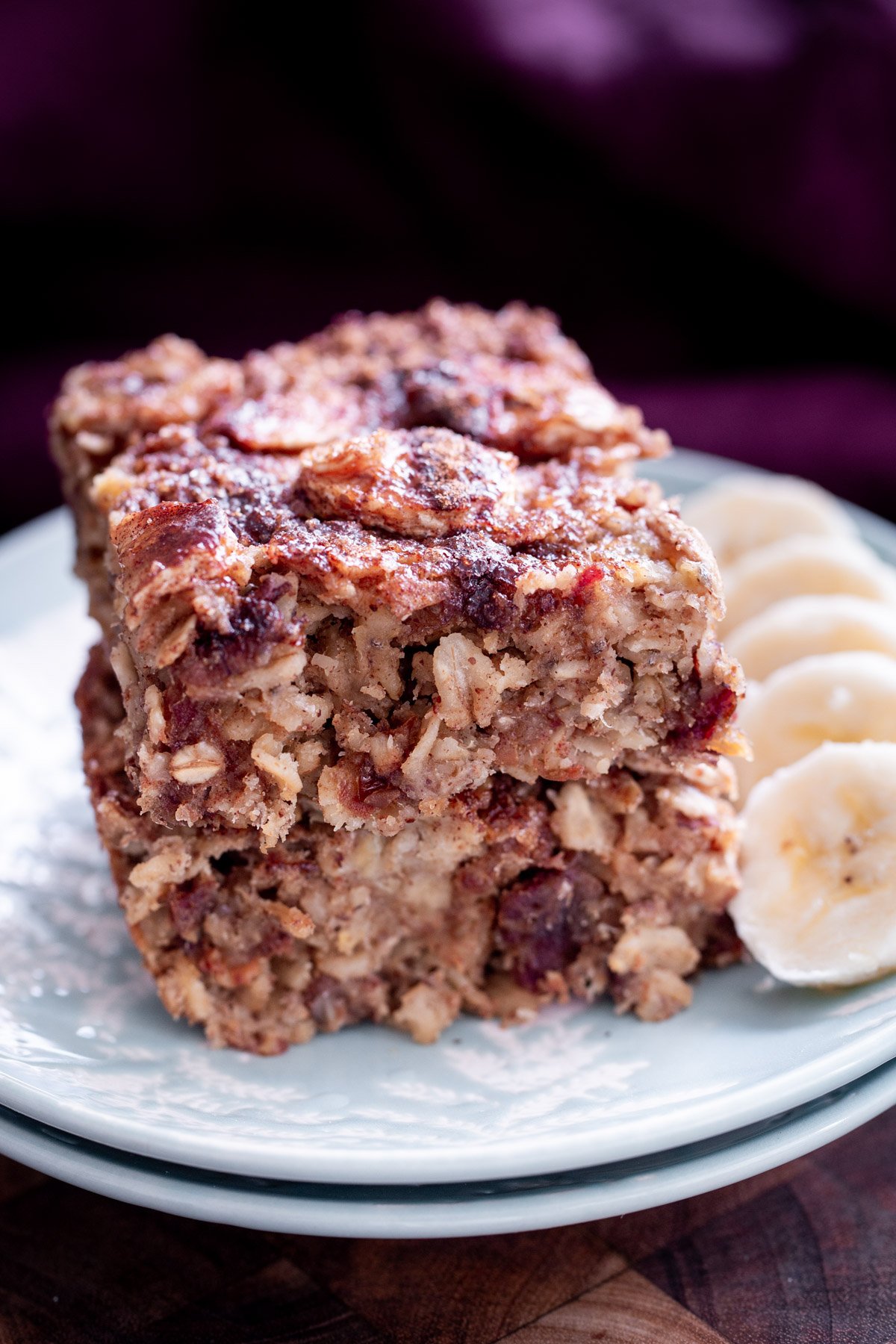 Banana Oatmeal Bars stacked with a side of sliced bananas