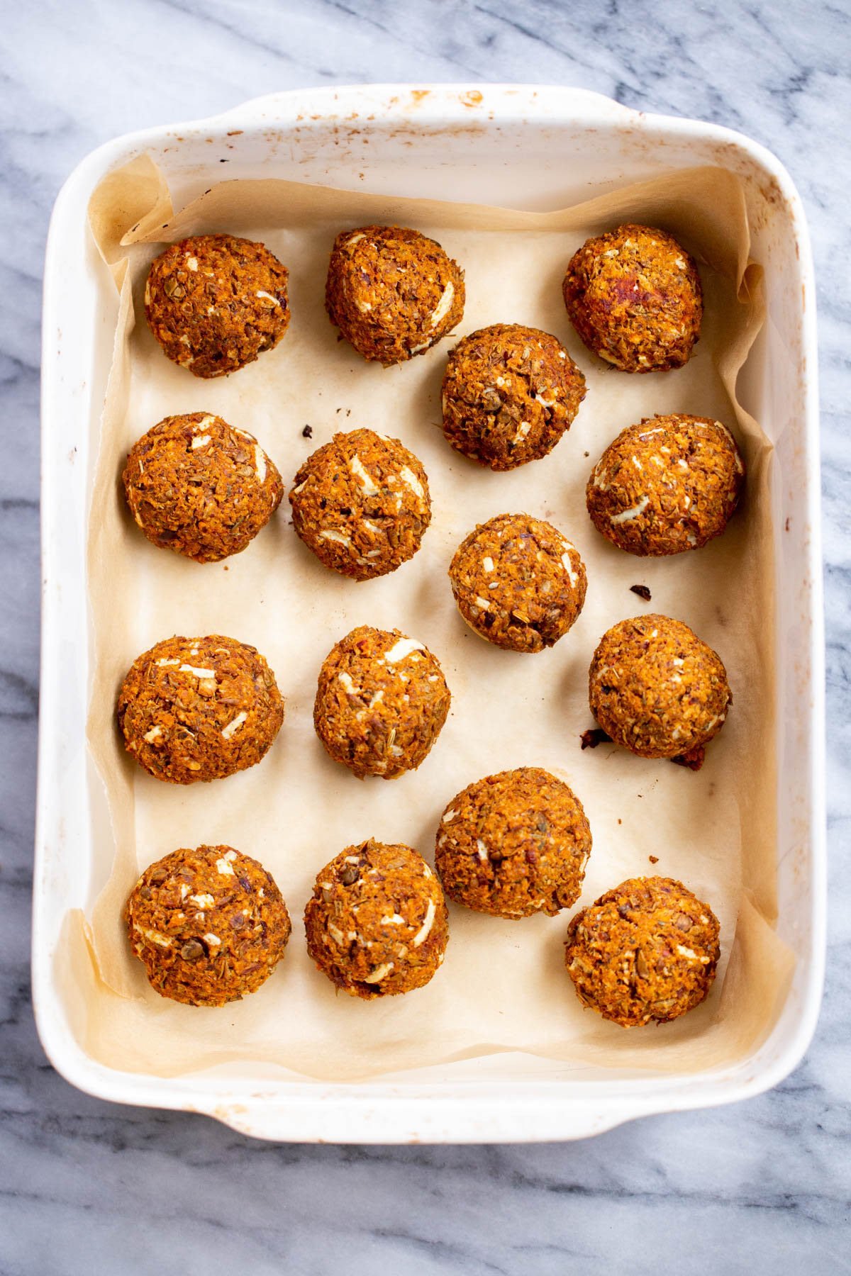 baked vegan lentil meatballs for meatball subs in a white casserole dish