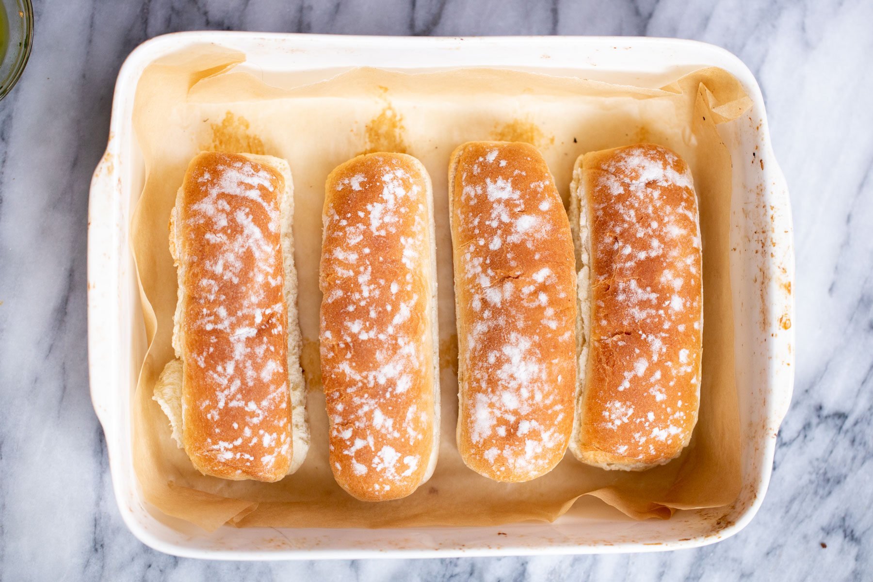 overhead shot of 4 baguette buns in a casserole dish