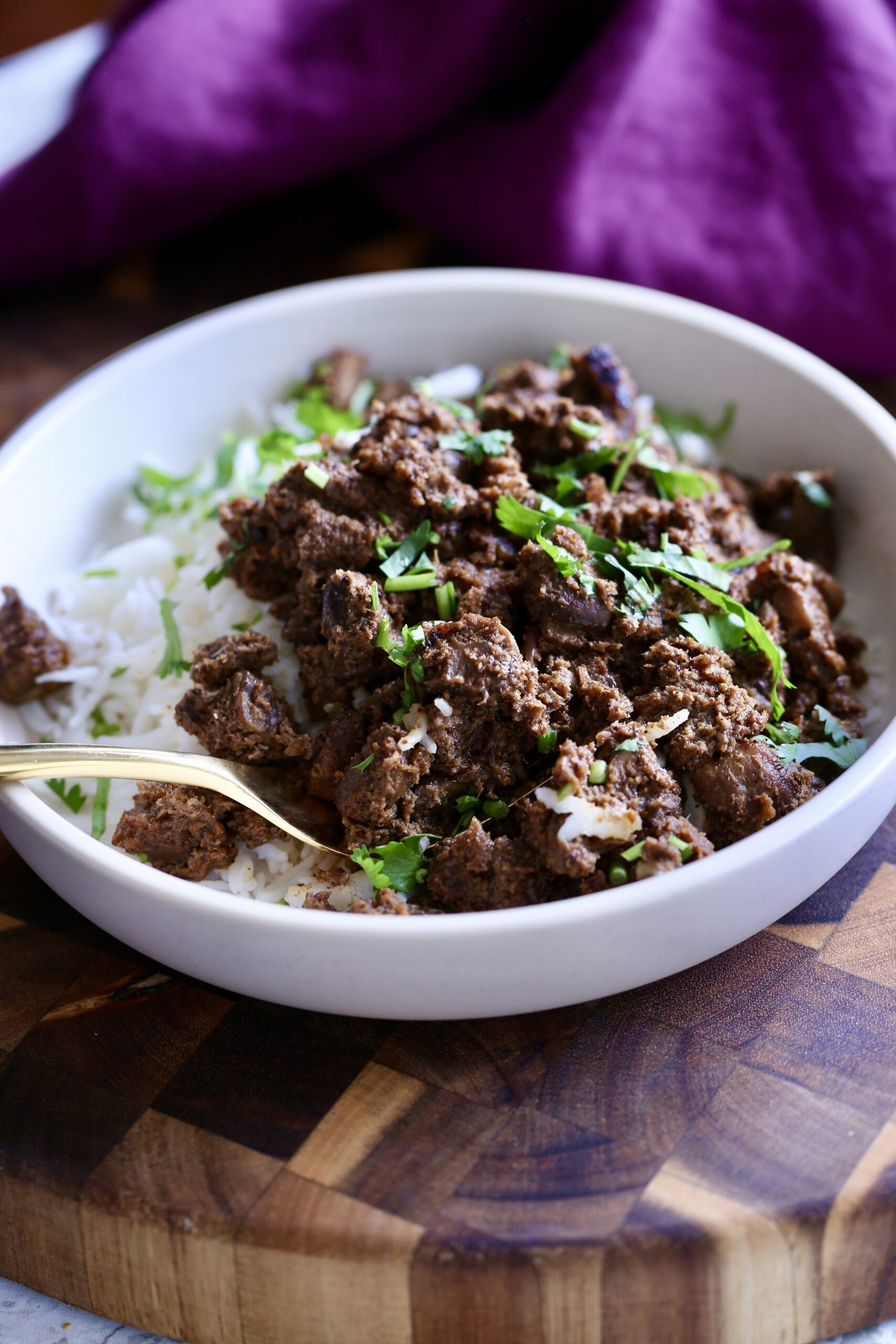mushroom xacuti a serving of vegan mushroom xacuti served with rice sprinkled with cilantro