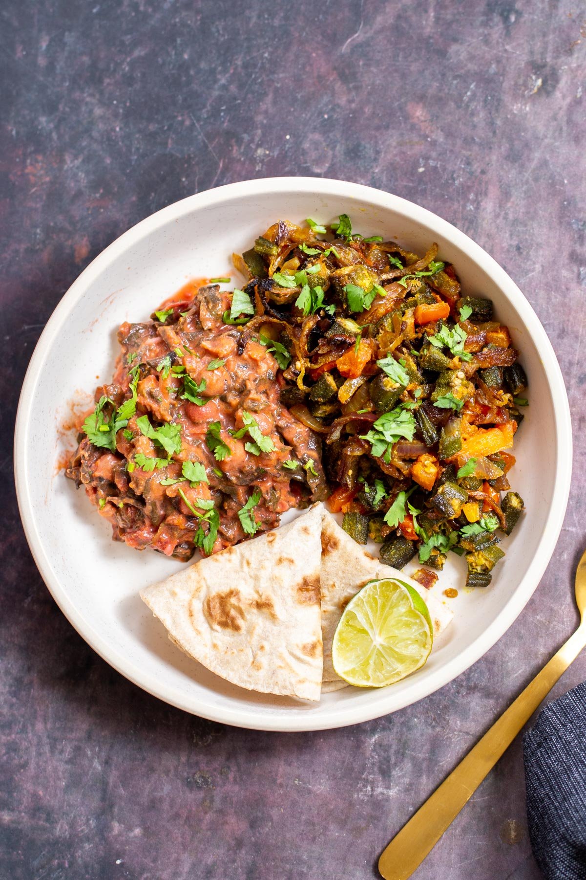 baked okra curry served with lime wedge and flatbread
