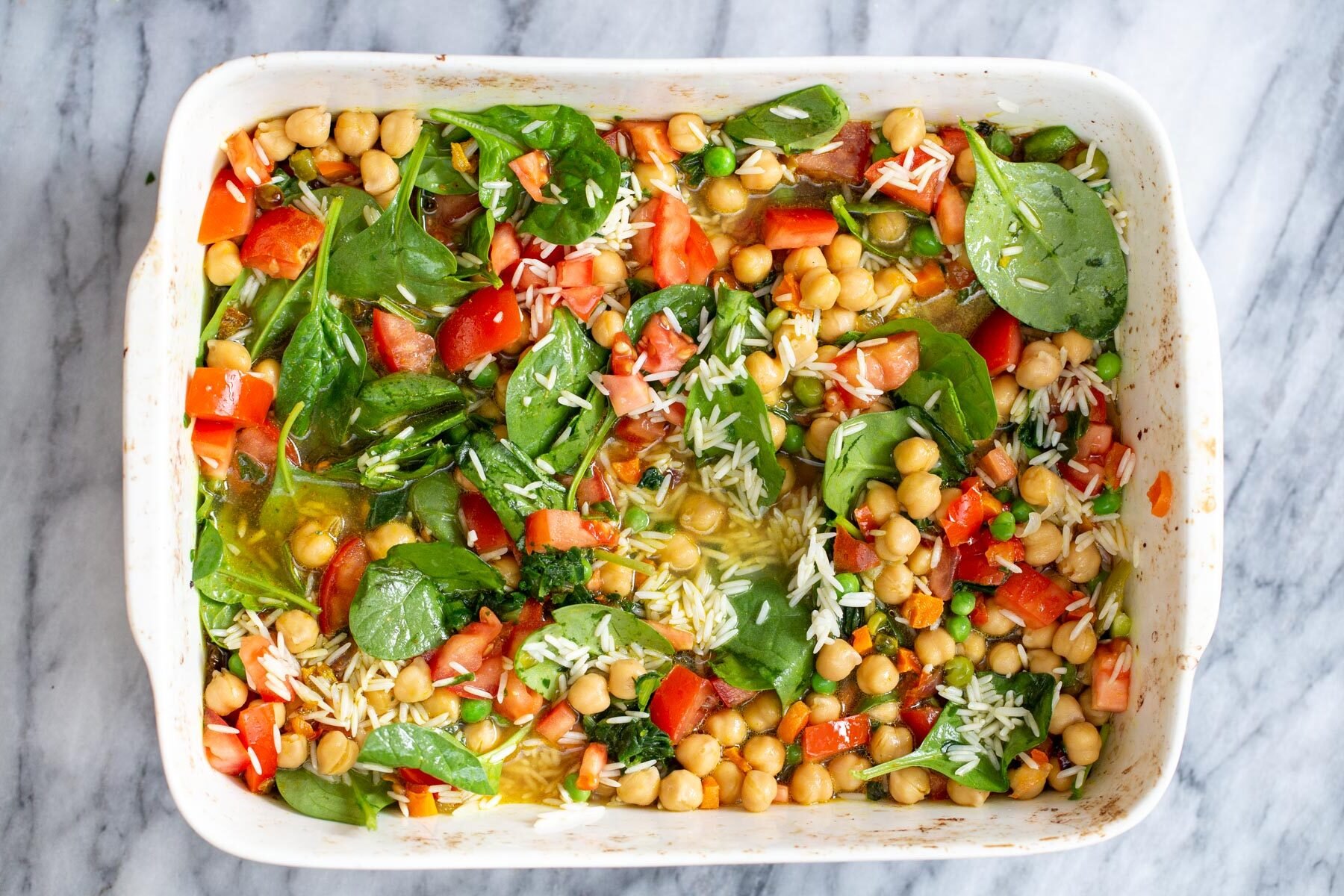 spinach, tomatoes, chickpeas and drained soaked rice in a casserole dish
