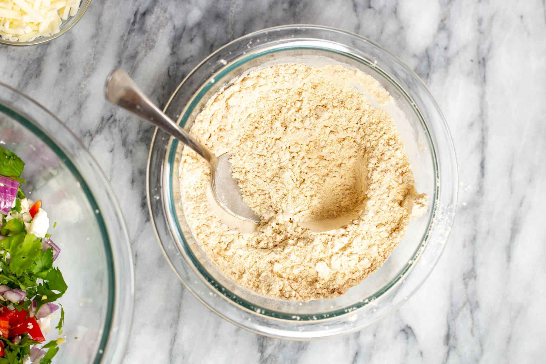 dry ingredients for vegan breakfast sandwich being combined in a glass bowl