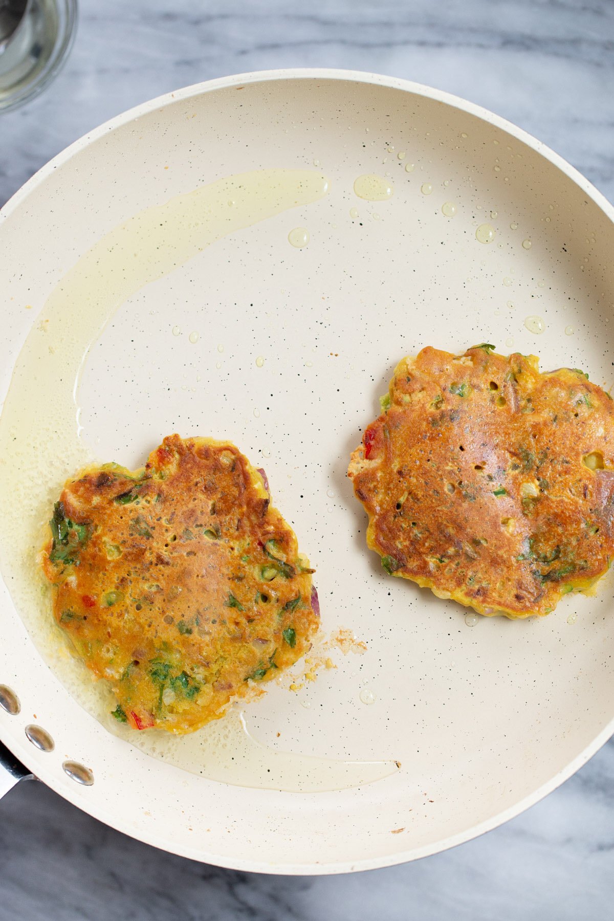 Chickpea veggie pancakes on a skillet