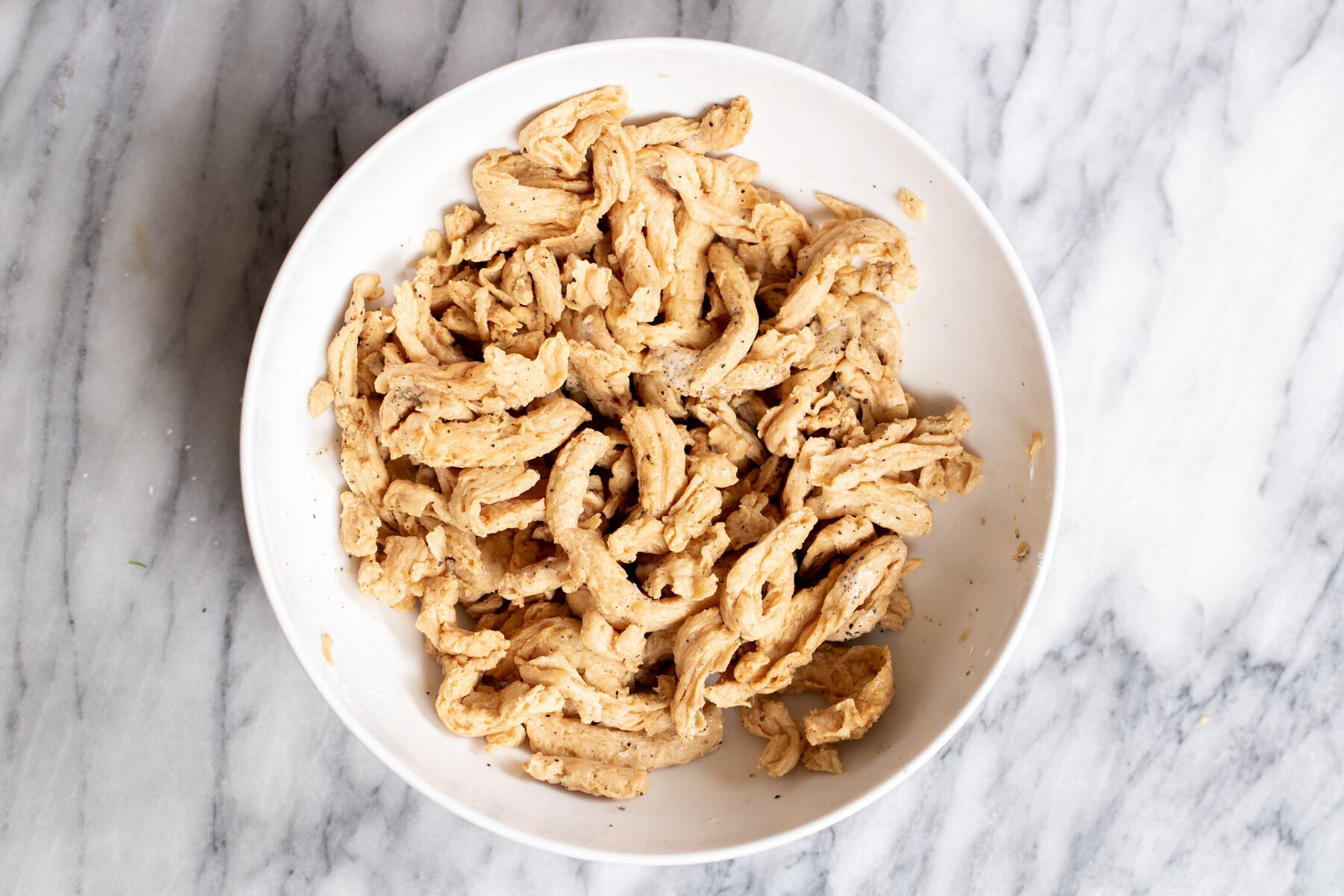 soaked vegan marinated soy curls in a white bowl