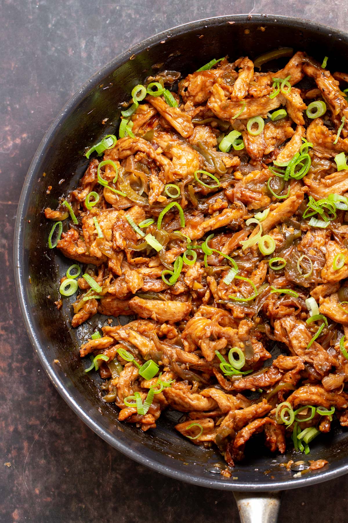Indo Chinese Soy Curl chilli Chicken in a skillet sprinkled with green onions