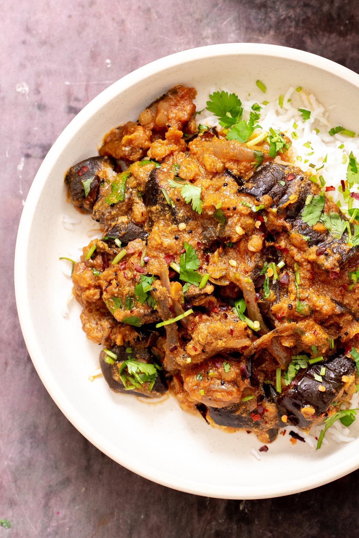 a serving of baked vegan eggplants served over rice sprinkled with cilantro