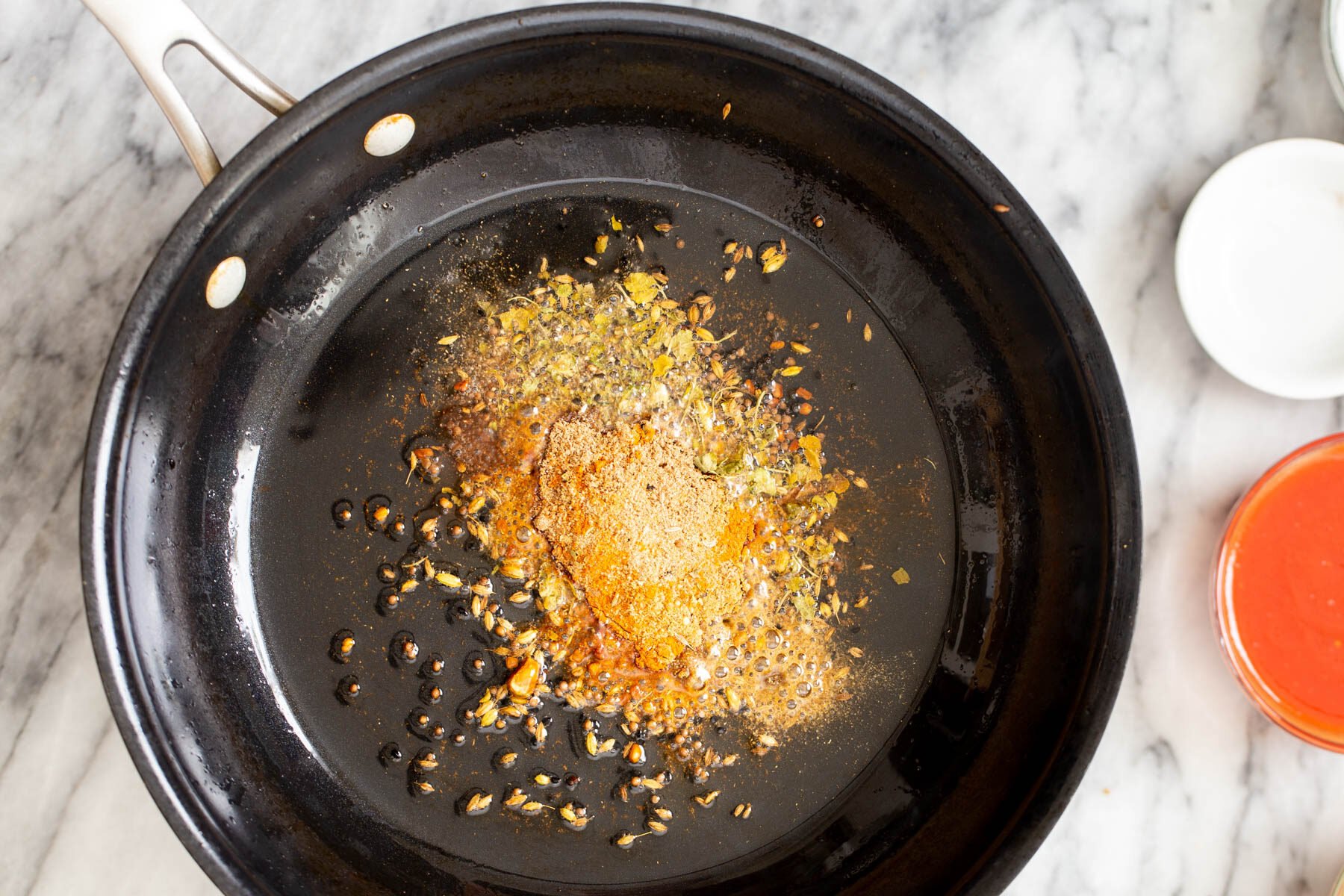 skillet with toasted whole spices and ground spices