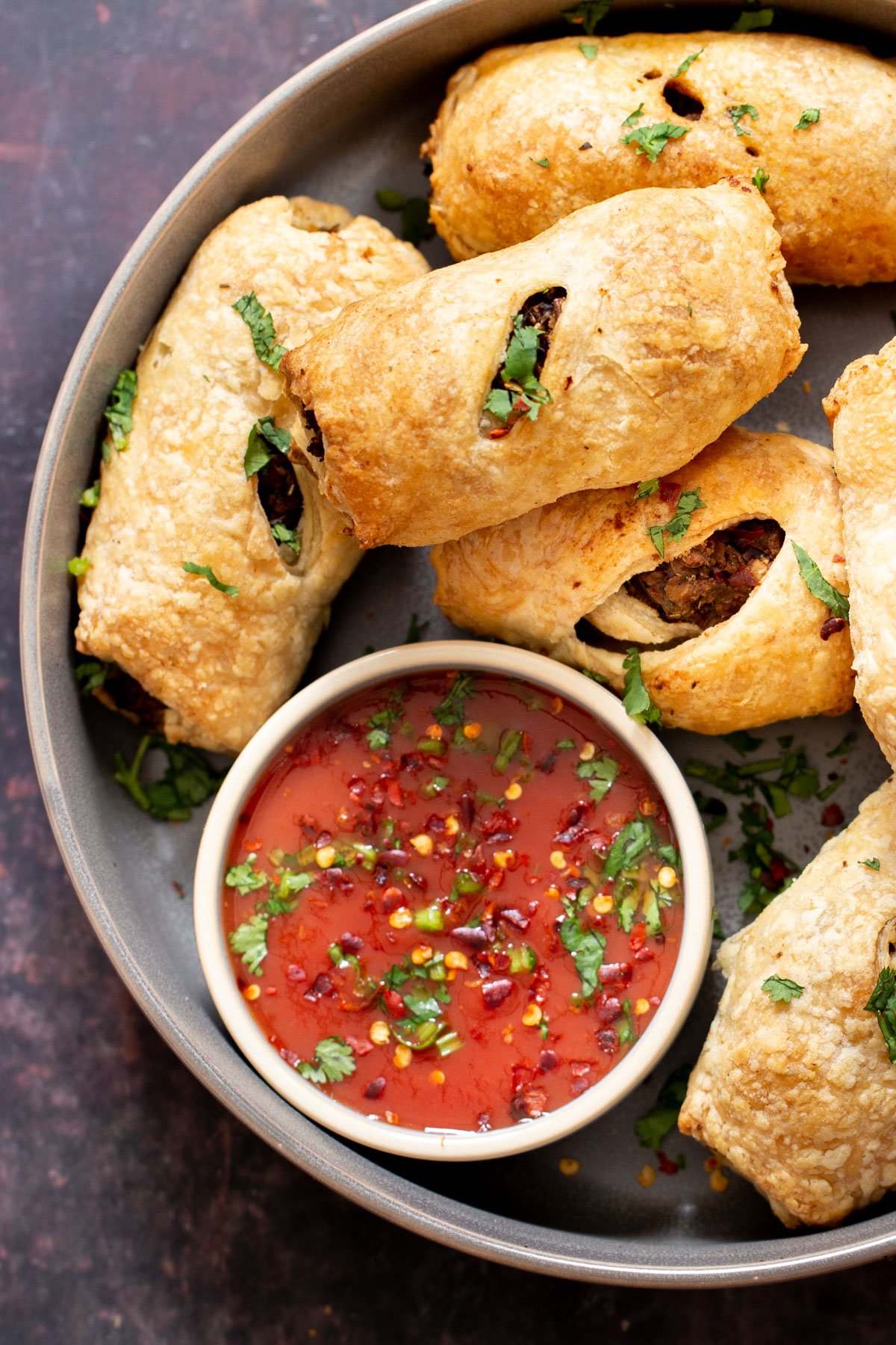 vegan sausage rolls with a small dish of tomato sauce