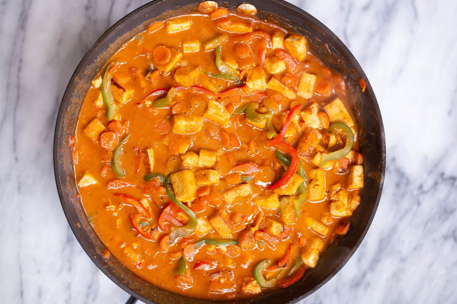 tofu cubes and sauteed bell peppers in creamy peanut butter sauce