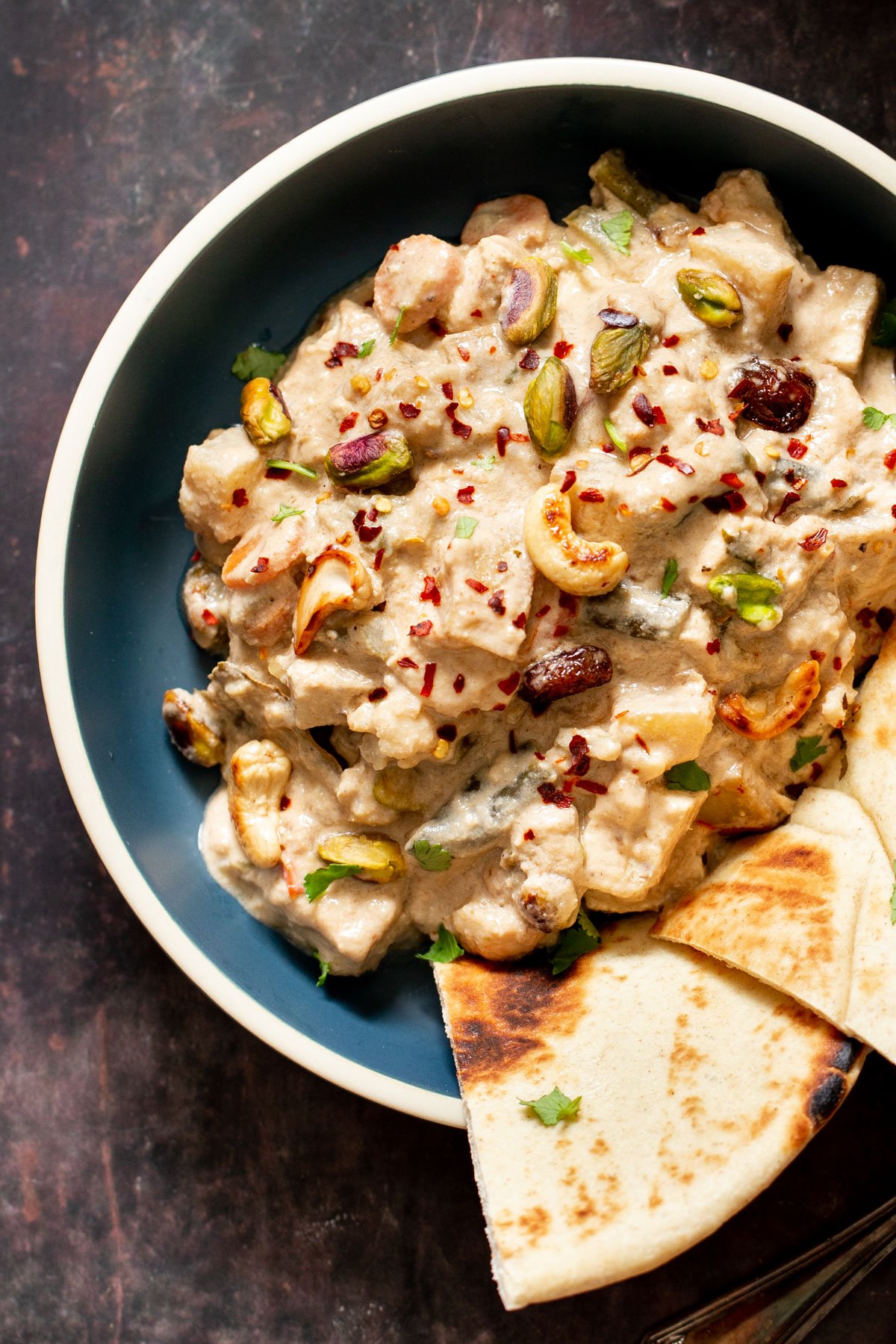a bowl with creamy Indian Navratan Korma sprinkled with chili flakes