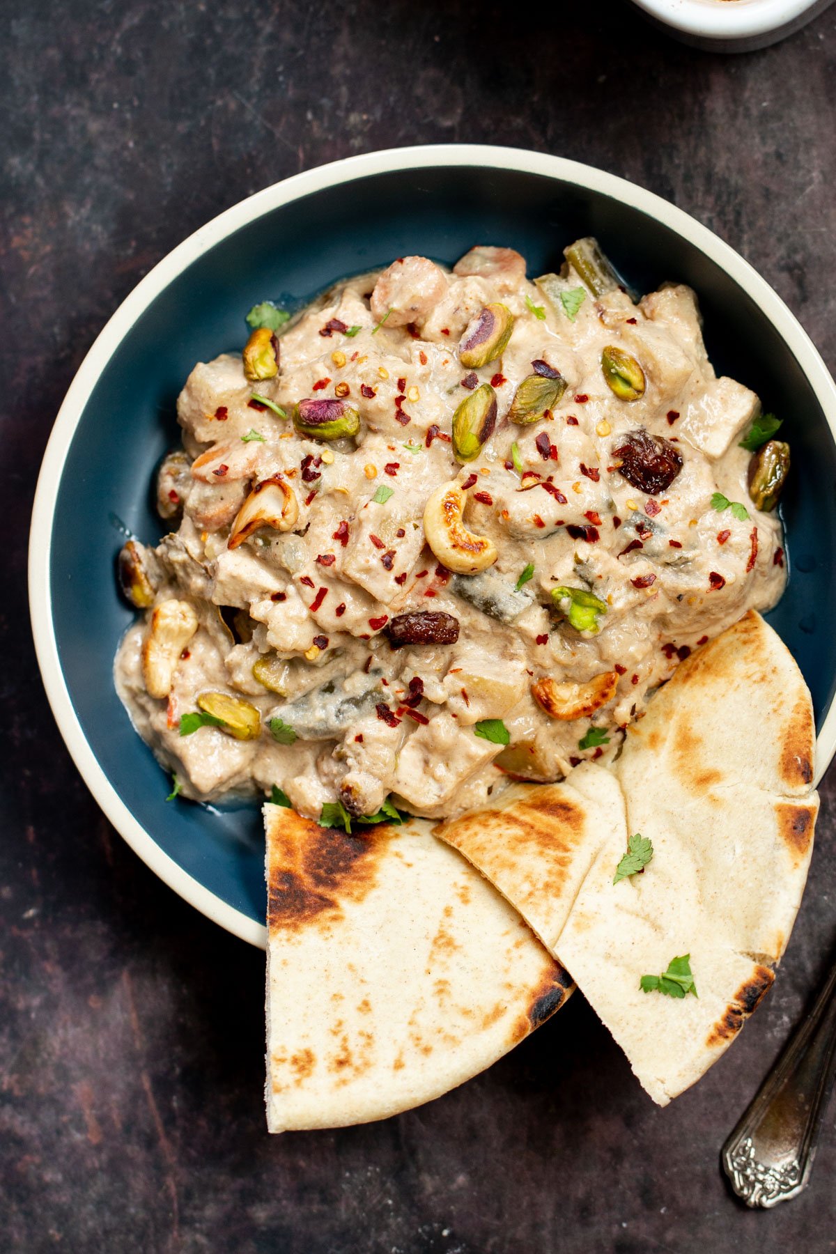 Navratan Korma  a bowl of Baked Vegan Navratan Korma topped with chopped nuts and red chili flakes