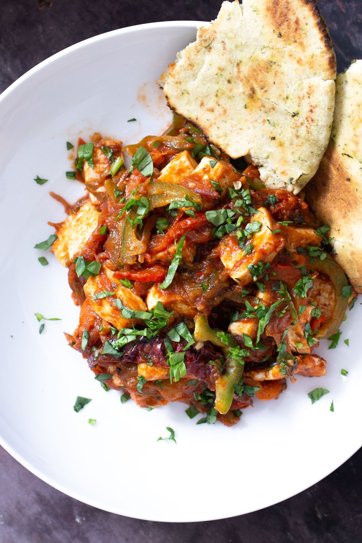 a serving of tofu jalfrezi served with a side of naan bread