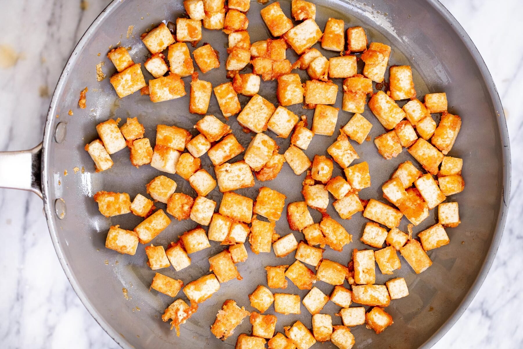 crispy tofu cubes in a sauteeing pan
